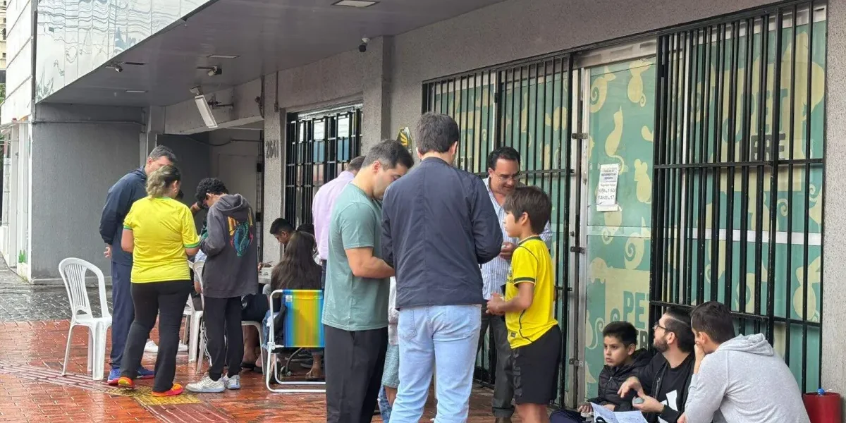 Chuva e jogo do Brasil não param crianças em troca de figurinhas