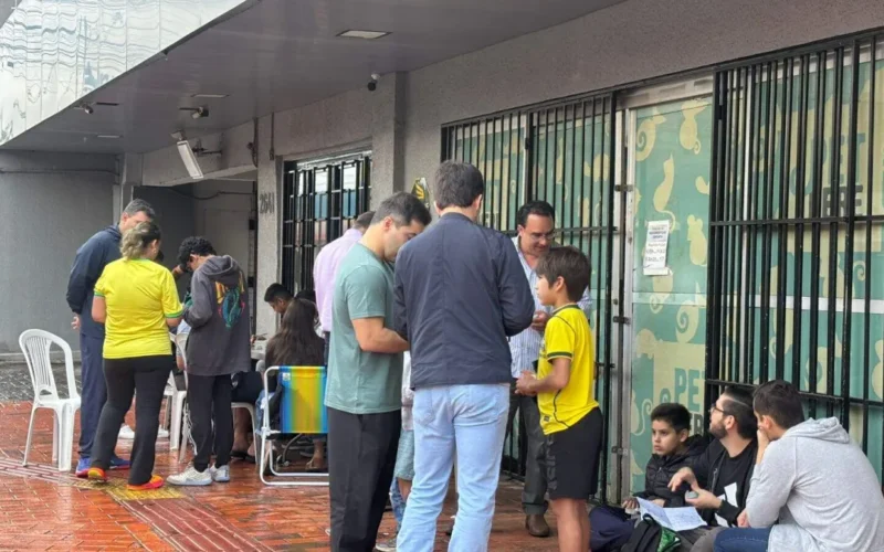 Chuva e jogo do Brasil não param crianças em troca de figurinhas